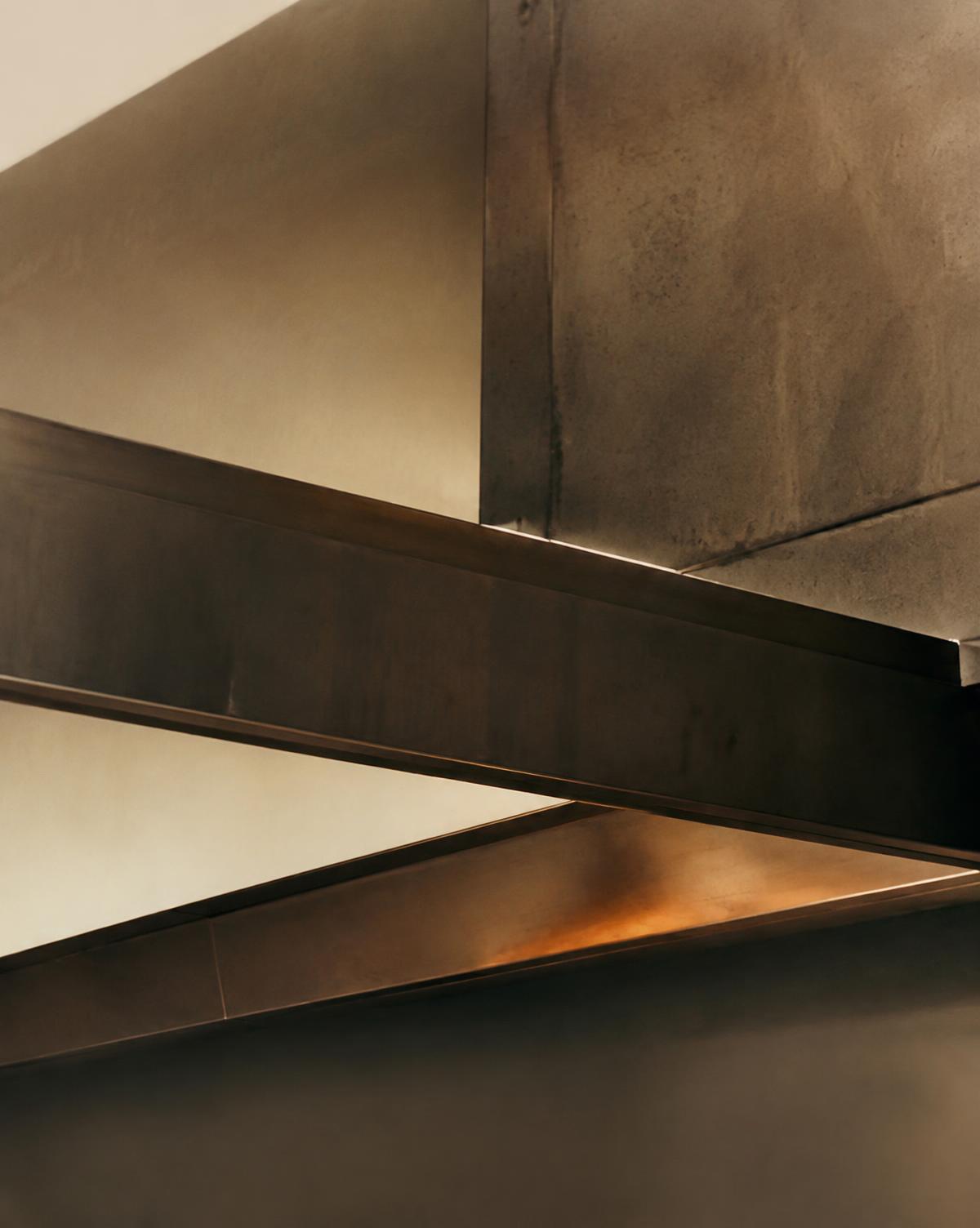 Abstract detail of intersecting bronze and steel architectural beams in warm light